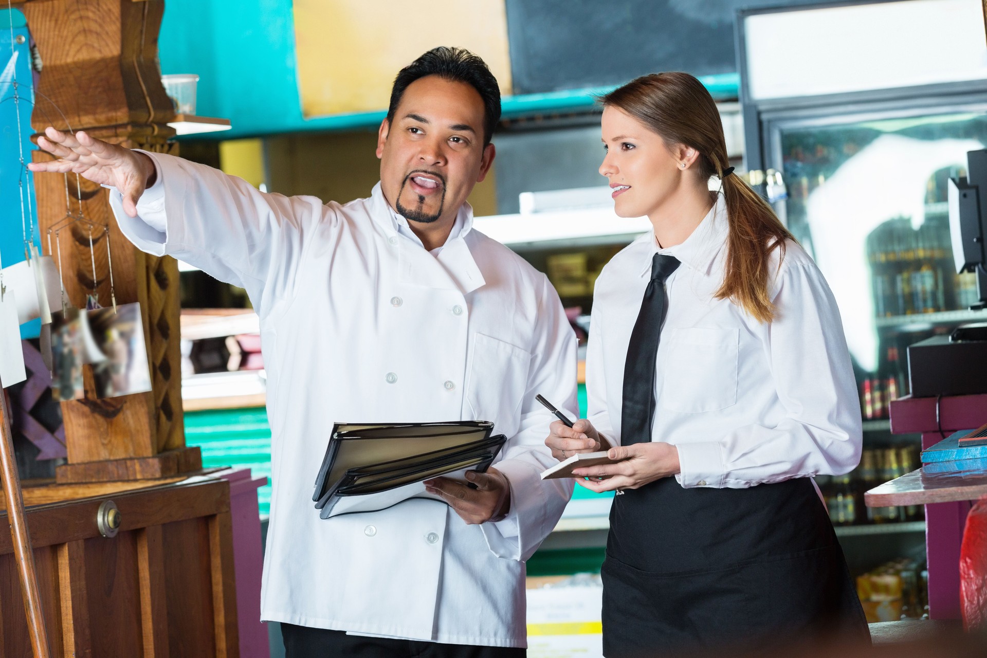 Restaurant chef training new waitress while explaining Mexican cuisine menu
